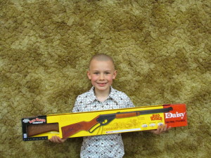 7 year old Logan Jensen of Moville IA  proudly displays the Red Ryder BB Gun he won at the 2014 Oak Ridge Gobblers Hunting Heritage Banquet.