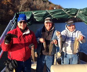 (photo by Mark Devore) (L to R) John Amick, Bill Elling and the author hold six nice trout during their trip to Lake Taneycomo.