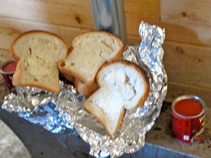Fresh walleye wrapped in tin foil with slices of homemade, buttered bread and two cans of pork ‘n beans, all prepared on the propane stove.