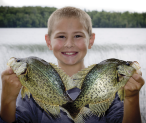 Kyle Thompson from Milford, IA holding up a pair of pre-spawn crappies. (Photo by Rocky Thompson)